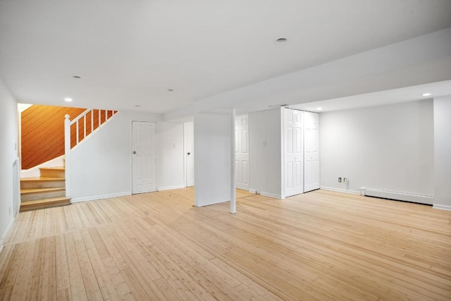 basement featuring light hardwood / wood-style floors and a baseboard radiator