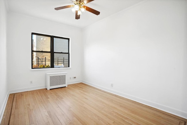 unfurnished room featuring ceiling fan, radiator, and light hardwood / wood-style flooring