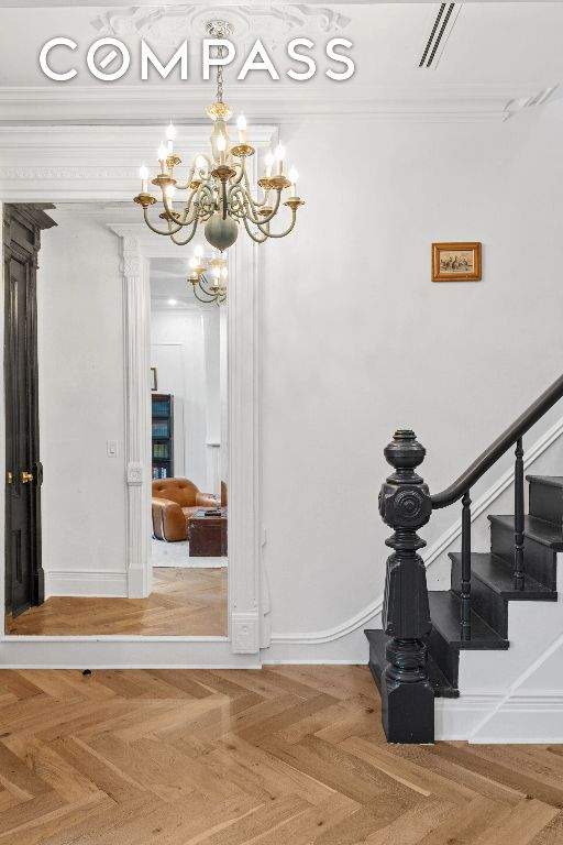 stairs with ornamental molding and parquet flooring