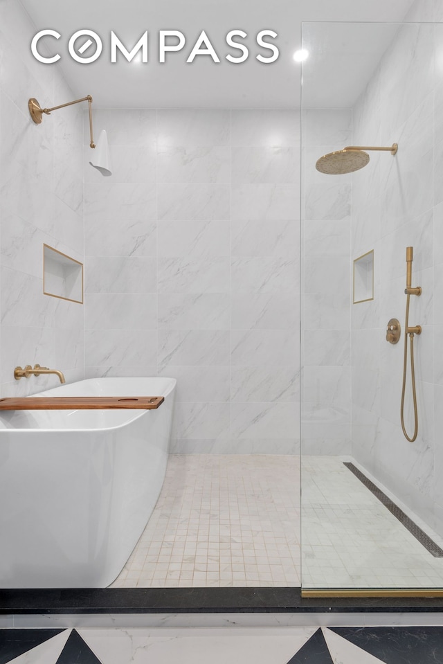 bathroom featuring a freestanding tub and tiled shower