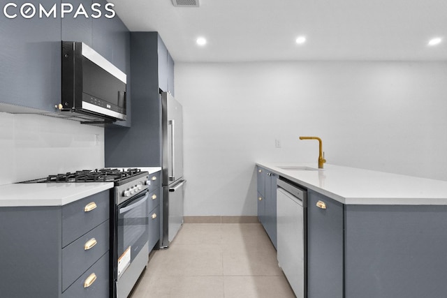 kitchen featuring gray cabinets, kitchen peninsula, sink, appliances with stainless steel finishes, and light tile patterned floors