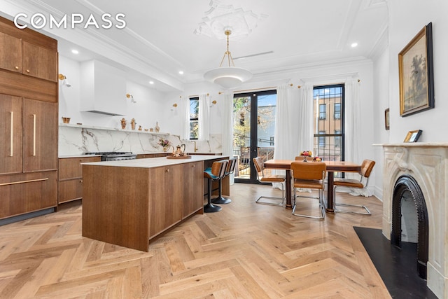 kitchen featuring brown cabinets, a kitchen island, recessed lighting, light countertops, and hanging light fixtures