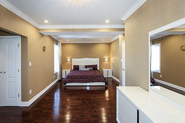 bedroom with dark hardwood / wood-style floors and crown molding