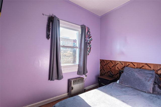 bedroom featuring radiator and hardwood / wood-style flooring