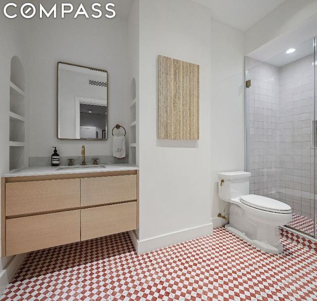 bathroom featuring built in shelves, toilet, a shower with door, and vanity