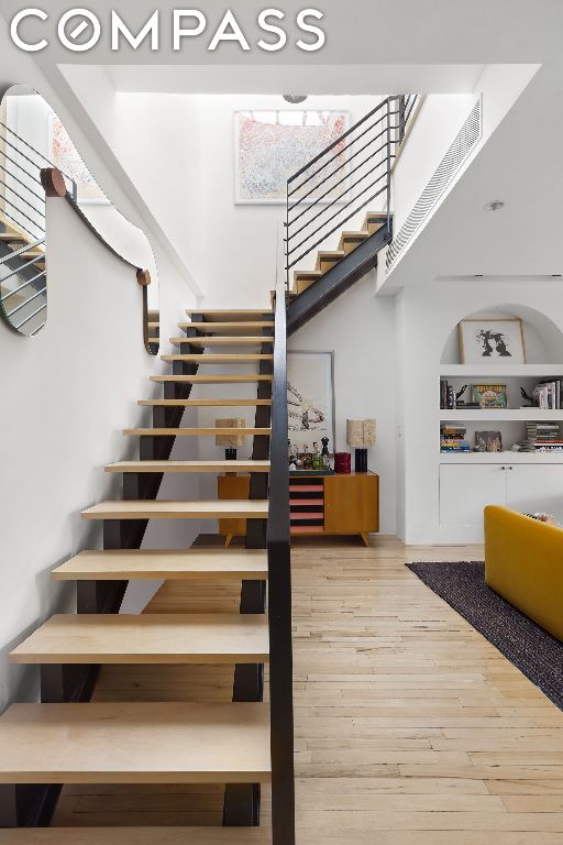 stairway featuring wood-type flooring and built in features