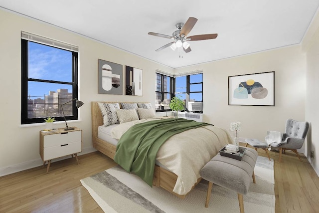 bedroom with ceiling fan and light hardwood / wood-style floors