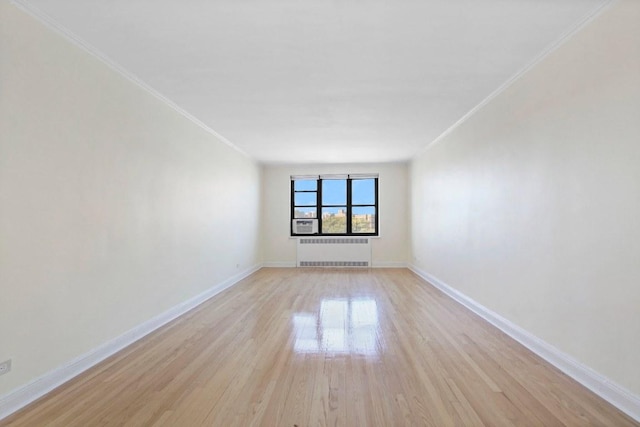 spare room featuring light wood-type flooring and radiator heating unit