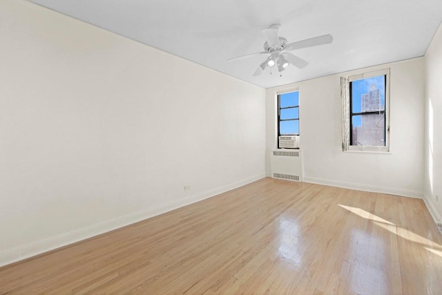 spare room with ceiling fan, radiator, and light hardwood / wood-style flooring