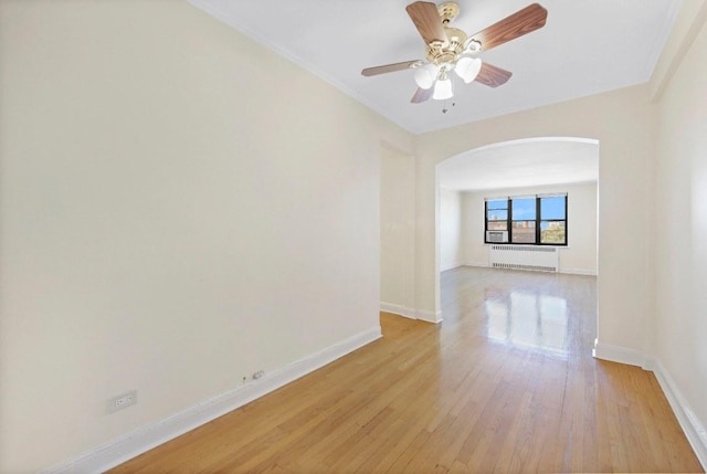 spare room with ceiling fan, light hardwood / wood-style flooring, and radiator heating unit