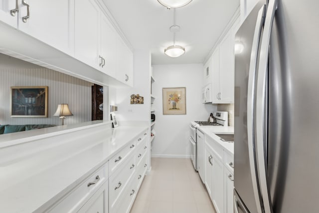 kitchen with white cabinetry, gas stove, and stainless steel fridge