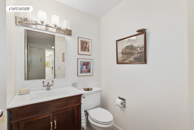 bathroom featuring toilet, baseboards, visible vents, and vanity