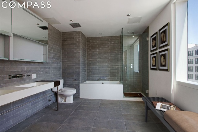 full bathroom with tile walls, vanity, tile patterned floors, independent shower and bath, and toilet