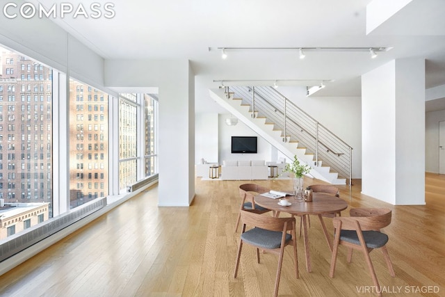 dining space featuring stairs, a view of city, and wood finished floors