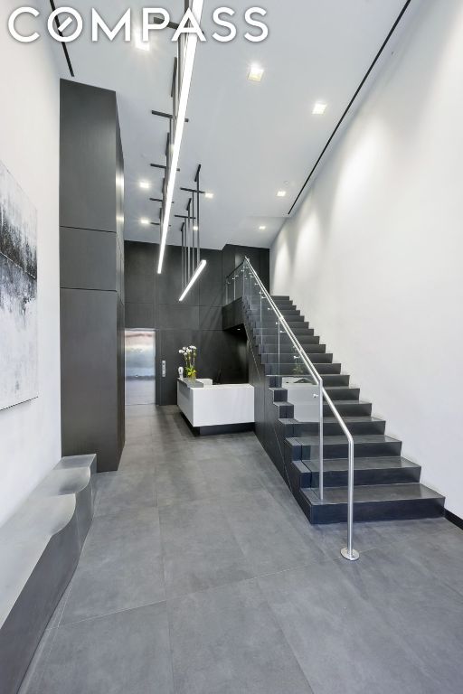 staircase featuring a high ceiling and concrete flooring