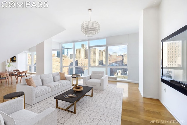 living room featuring light hardwood / wood-style flooring, expansive windows, and a chandelier