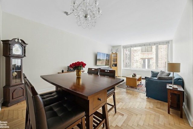 dining area with light parquet floors and an inviting chandelier