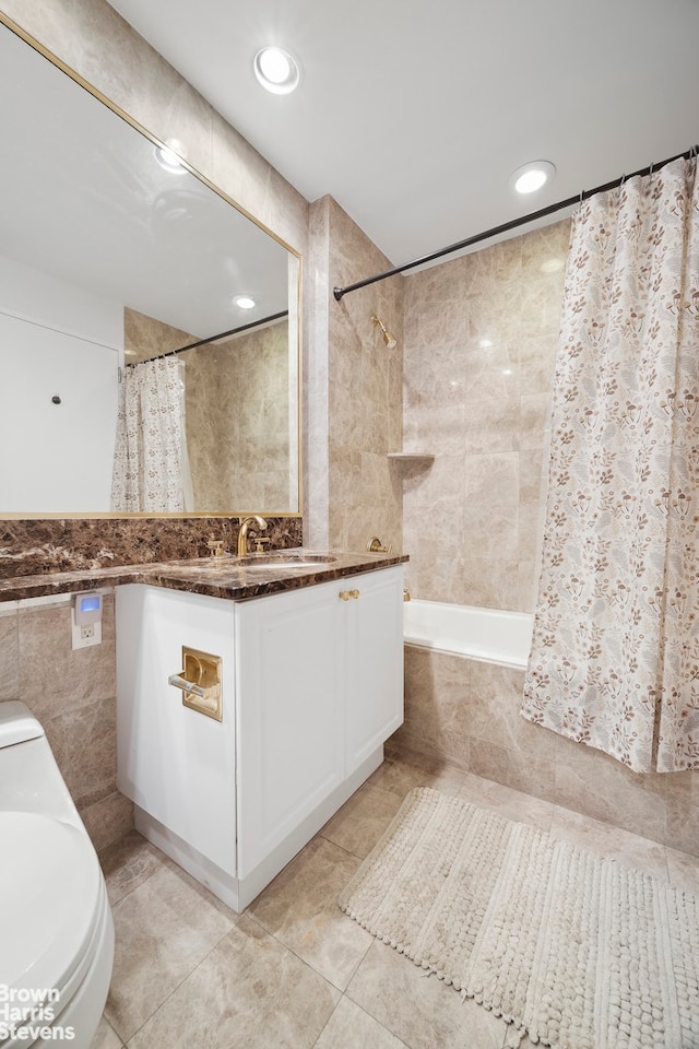 bathroom with tiled shower / bath, tile walls, toilet, vanity, and tile patterned floors