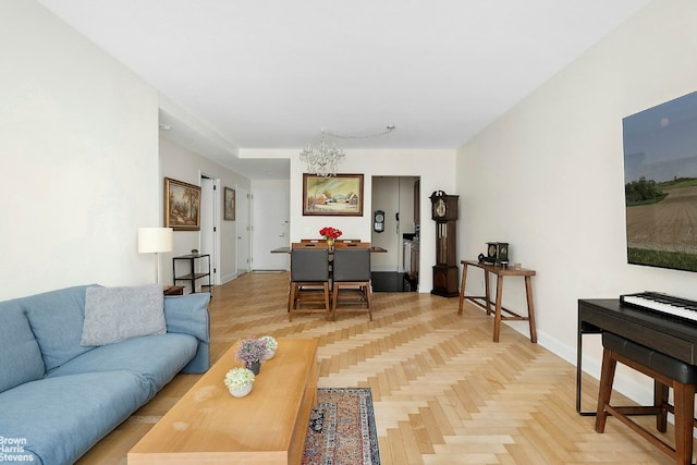 living area featuring a notable chandelier and baseboards