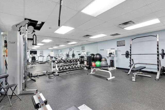 exercise room with a drop ceiling and visible vents