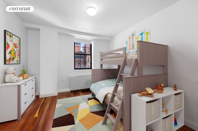 bedroom with baseboards, visible vents, and wood finished floors