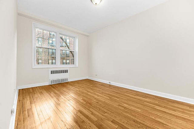 empty room featuring light hardwood / wood-style floors and radiator heating unit