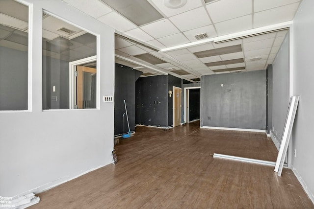 empty room featuring a paneled ceiling and dark hardwood / wood-style flooring