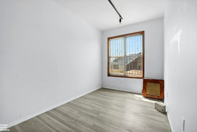 spare room with rail lighting and light hardwood / wood-style flooring