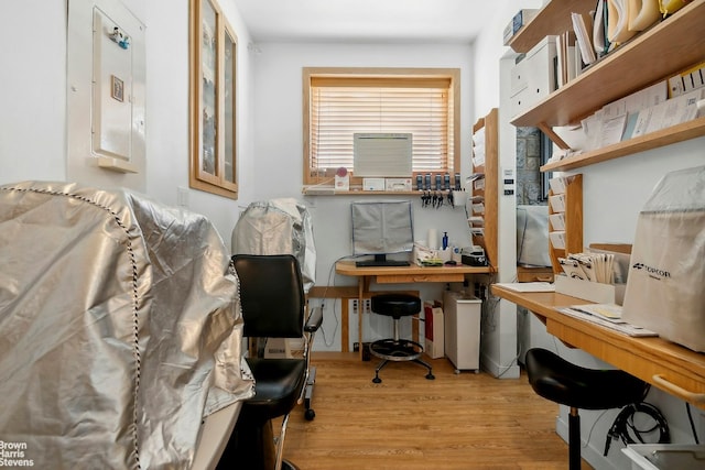 home office featuring electric panel and light hardwood / wood-style floors