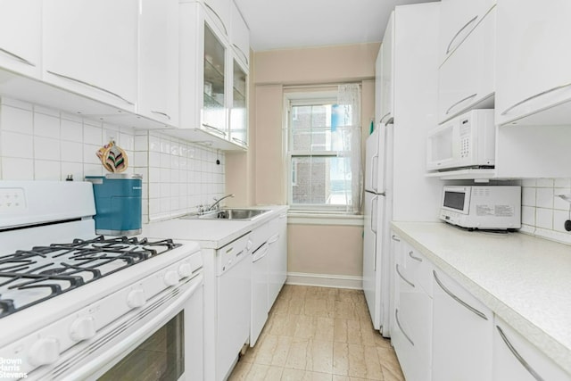 kitchen featuring white cabinetry, sink, white appliances, and tasteful backsplash