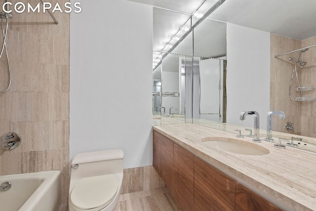 full bathroom featuring toilet, tiled shower / bath, and vanity