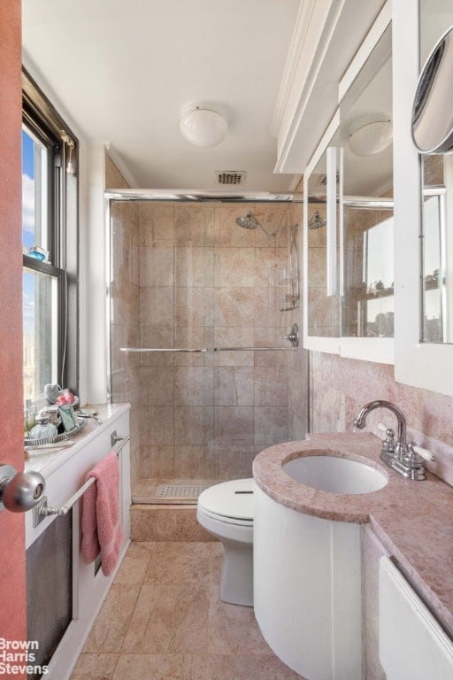 bathroom featuring vanity, an enclosed shower, and toilet