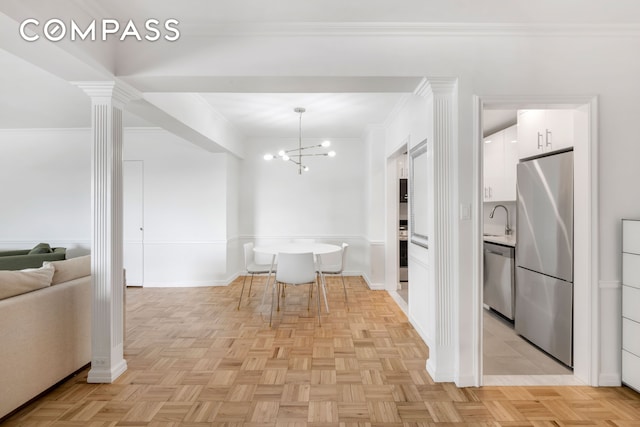 dining area featuring ornamental molding, decorative columns, baseboards, and an inviting chandelier