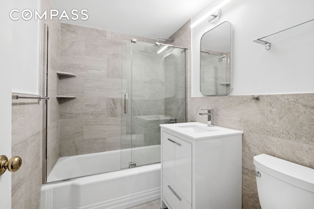 45 Sutton Pl S Unit 15G, New York City, NY 10022 - bathroom with vanity, bath / shower combo with glass door, and tile walls