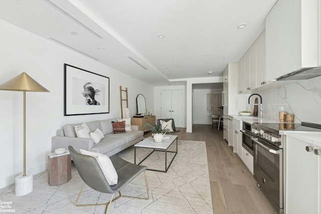 living room with light hardwood / wood-style flooring and sink