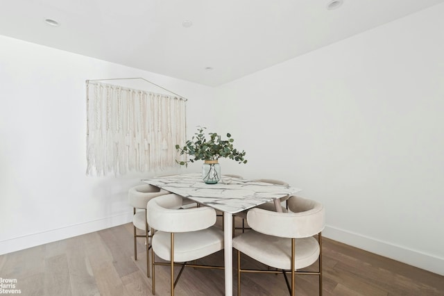 dining space with wood finished floors and baseboards