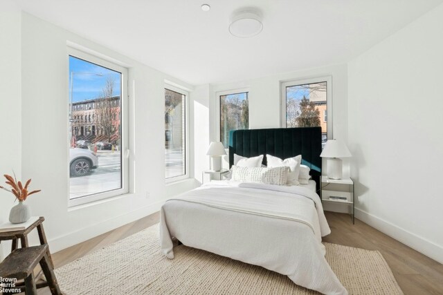 bedroom featuring multiple windows and light wood-type flooring