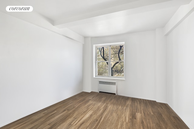 empty room featuring radiator heating unit, dark wood finished floors, visible vents, and baseboards