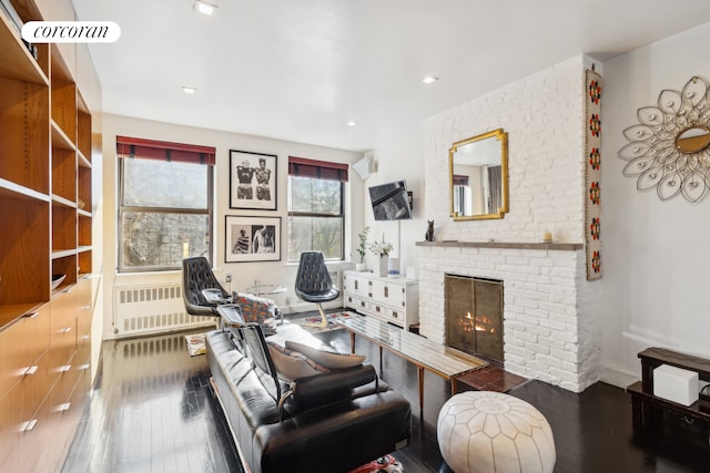 office area with wood-type flooring, a fireplace, and radiator heating unit