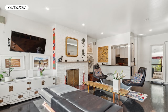 living room featuring dark wood-type flooring and a fireplace