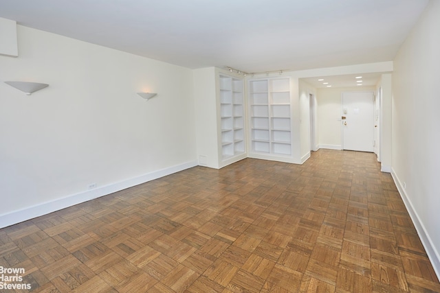 spare room with dark parquet floors