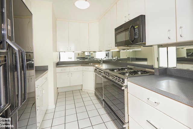 kitchen featuring light tile patterned floors, plenty of natural light, black appliances, and white cabinets