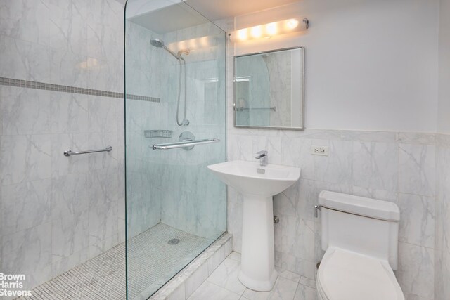 bathroom with walk in shower, tile walls, and toilet