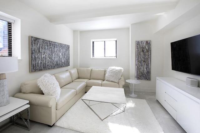 living area with beamed ceiling and baseboards