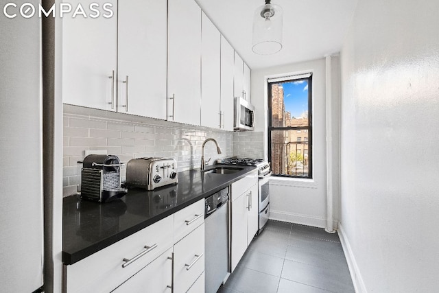 kitchen with appliances with stainless steel finishes, backsplash, white cabinetry, and sink