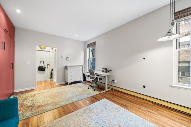 office area featuring a baseboard radiator and wood-type flooring