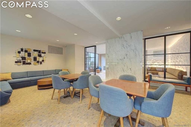 carpeted dining area with a wall of windows