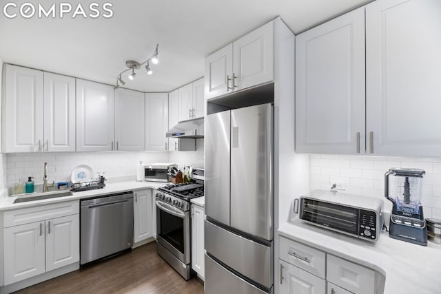 kitchen featuring appliances with stainless steel finishes, white cabinetry, tasteful backsplash, and sink