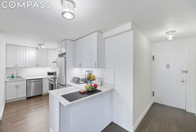 kitchen with tasteful backsplash, stainless steel appliances, and white cabinetry