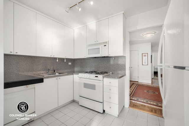 118 E 60th St Unit 28G, New York City, NY 10022 - kitchen featuring white appliances, a sink, light tile patterned floors, and white cabinets
